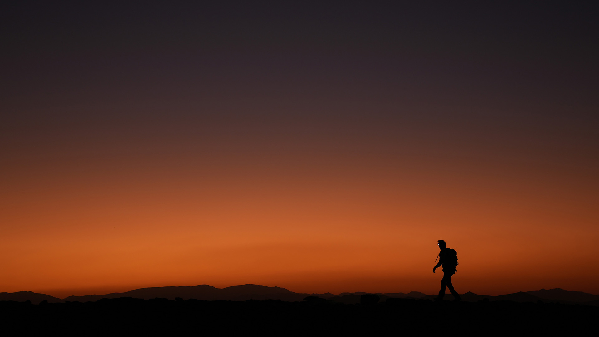 ألبرت لين يسير في الصحراء وقت غروب الشمس أثناء تصوير... [Photo of the day - مايو 2023]