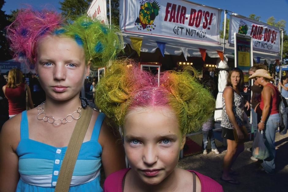 Sisters with rainbow coloured hairstyles and matching glitter in Saint Paul, Minnesota. USA. [Photo of the day - September 2011]