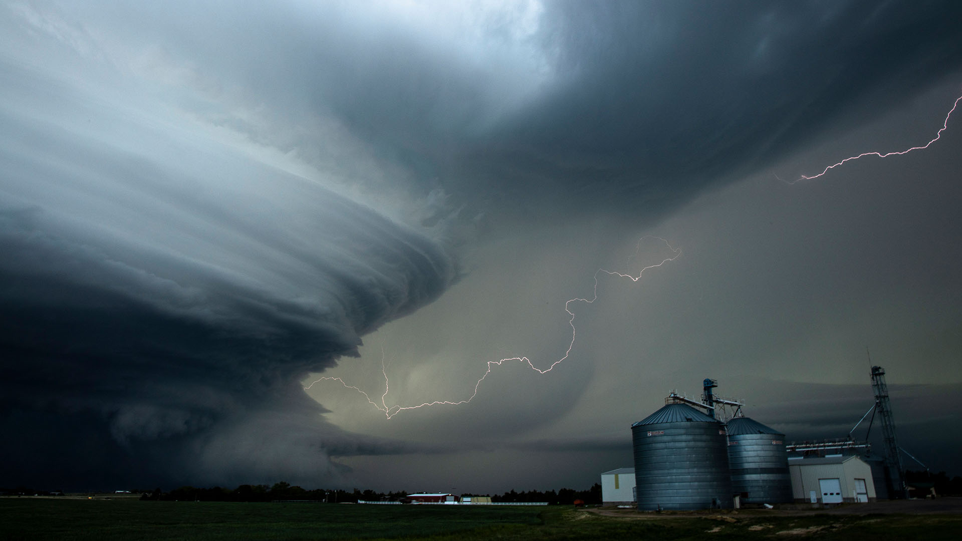 A 'supercell' storm towers over a farm grain elevator in Nebraska, USA. This is from... [Photo of the day - مارس 2024]