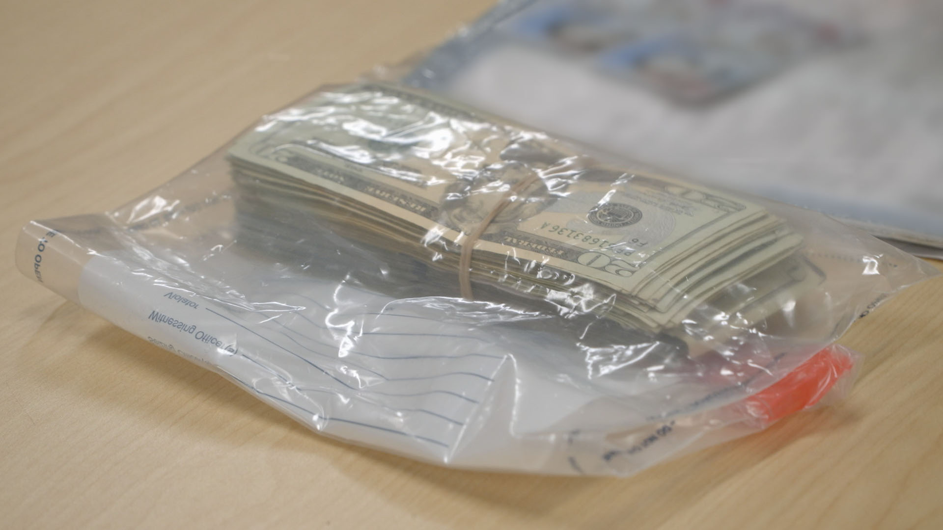 A stack of undeclared currency was placed in an evidence bag on an inspection table after it was... [Photo of the day - May 2024]