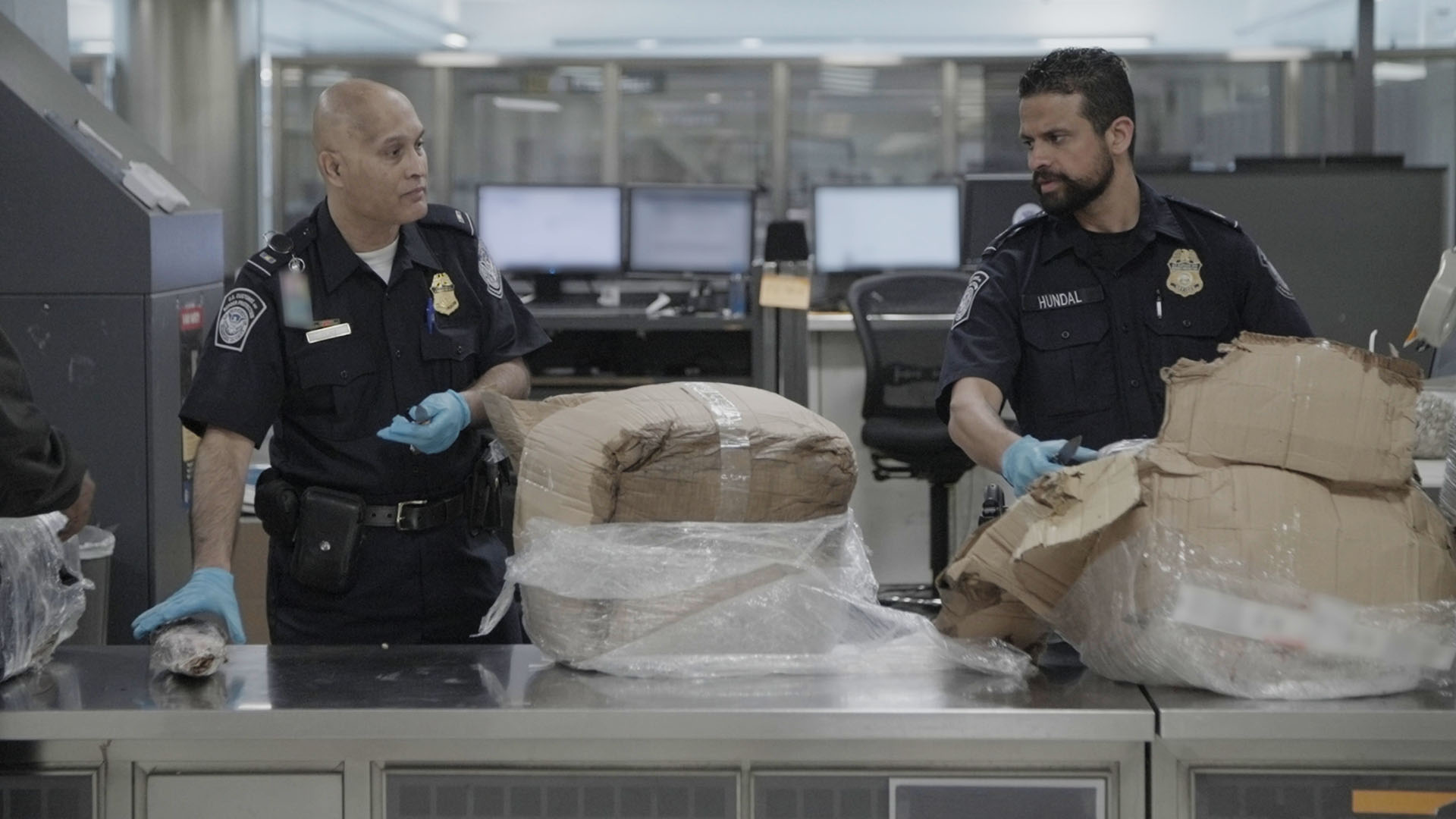 CBP Officers Islam and Hundal use knives to inspect a passenger's boxes, searching for customs... [Photo of the day - May 2024]