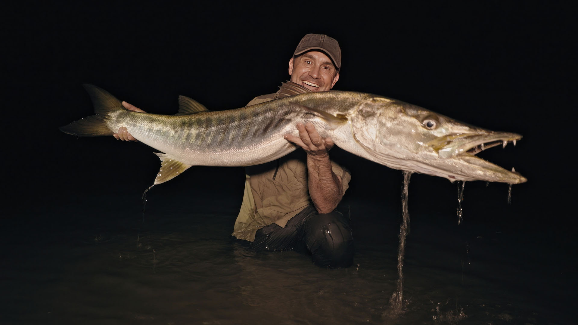 Cyril holding large barracuda at night. This is from Last of the Giants: Wild Fish Season 3. [Photo of the day - May 2024]
