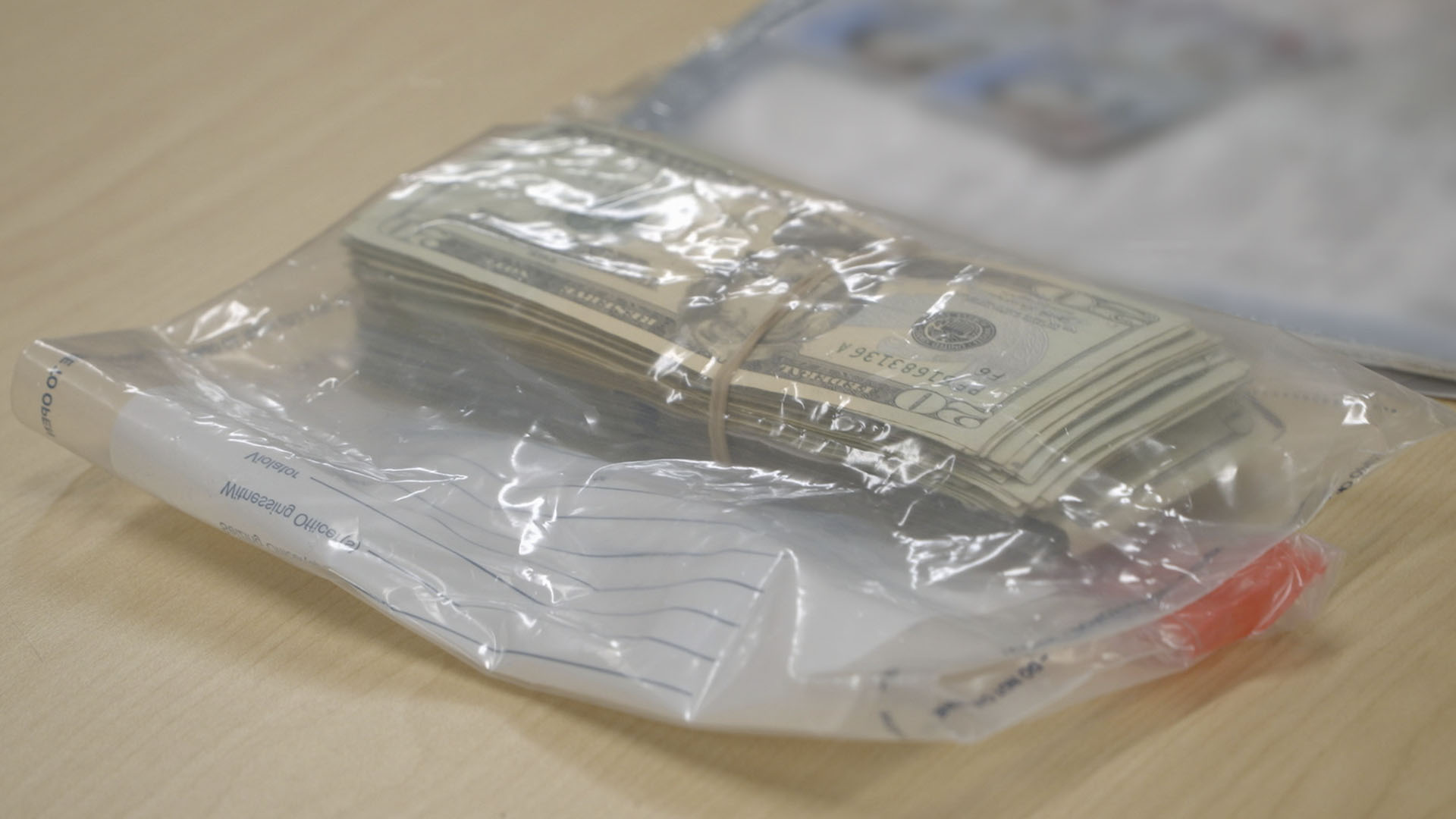 A stack of undeclared currency was placed in an evidence bag on an inspection table after it was... [Photo of the day - September 2024]