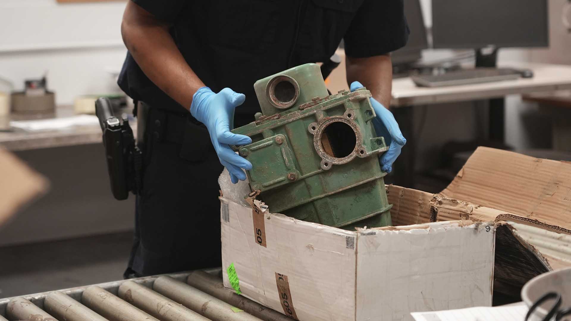 CBP Supervisory Officer Keller extracts a machine part out of a shipment box to inspect it for... [Photo of the day - October 2024]