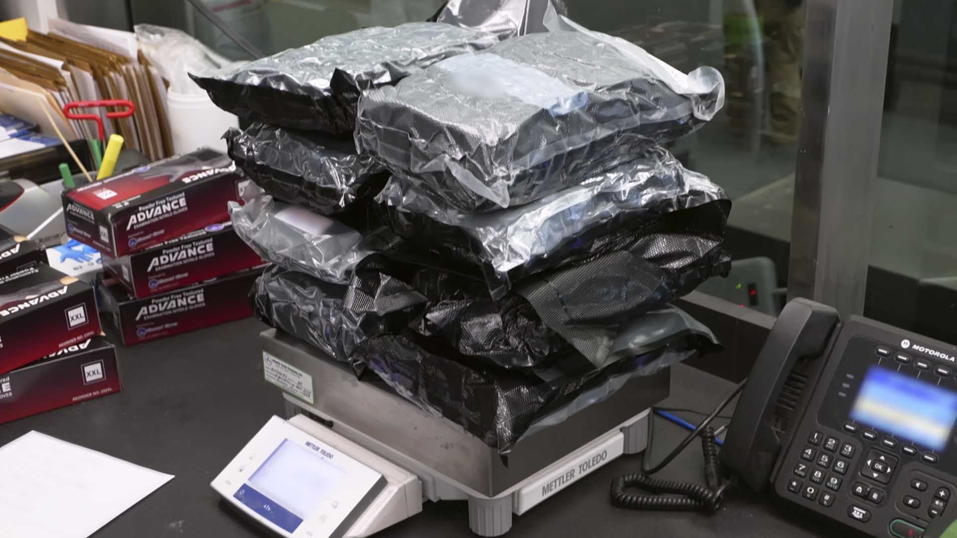 Multiple packages of marijuana are weighed on a scale after they were discovered inside of a... [Photo of the day - October 2024]