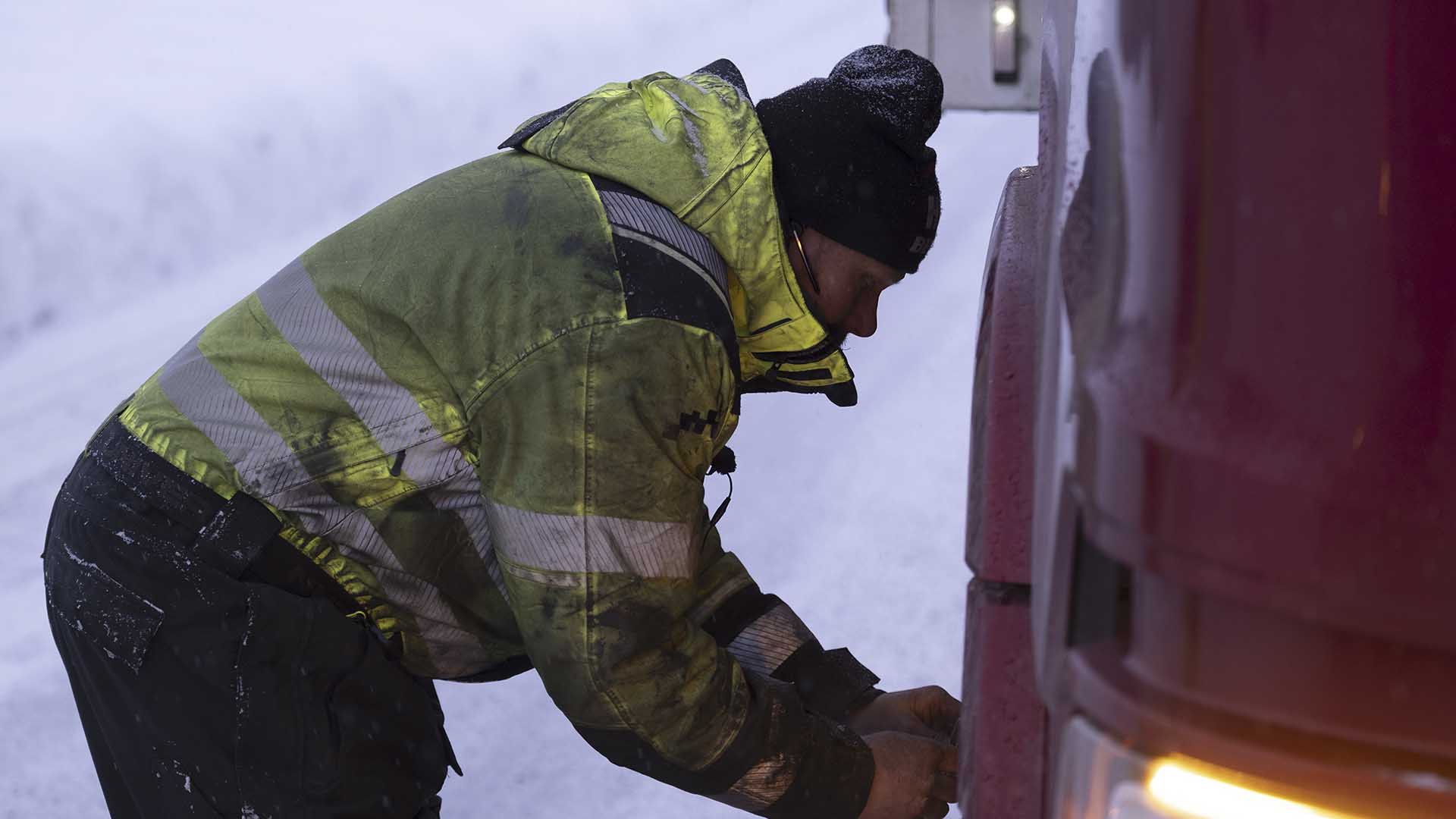 Thord attaching chains to the truck wheels.  This is from Ice Road Rescue, season 9. [Photo of the day - October 2024]