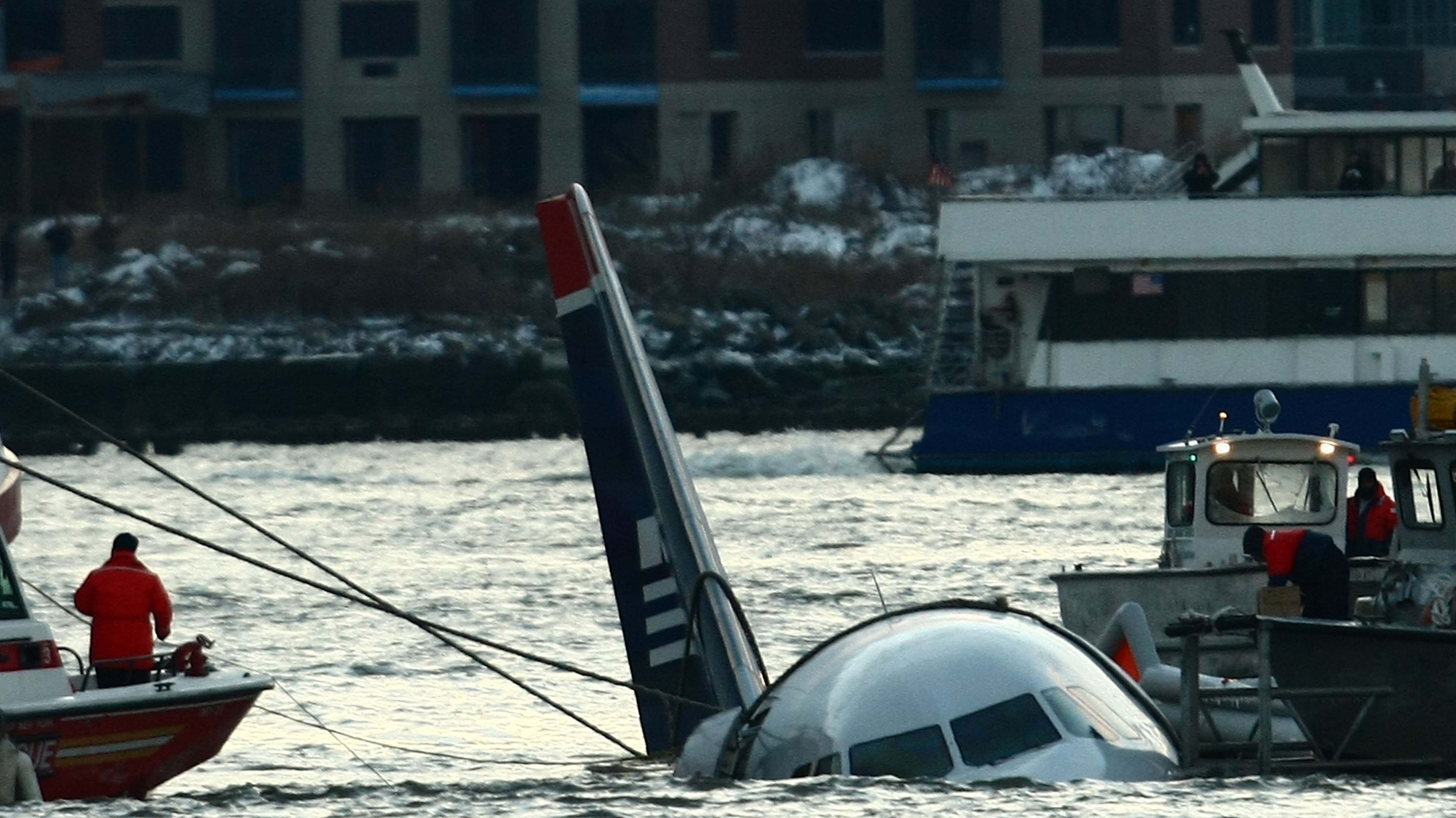 Rescue boats float next to a US Airways plane floating in the water after crashing into the... [Photo of the day - January 2025]