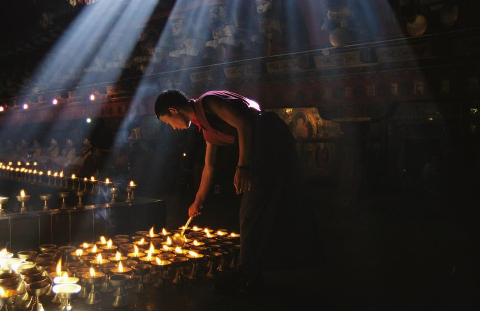 A buddhist monk lights devotional lamps inside Jokhang Temple, Lhasa. Tibet. [Photo of the day - October 2011]