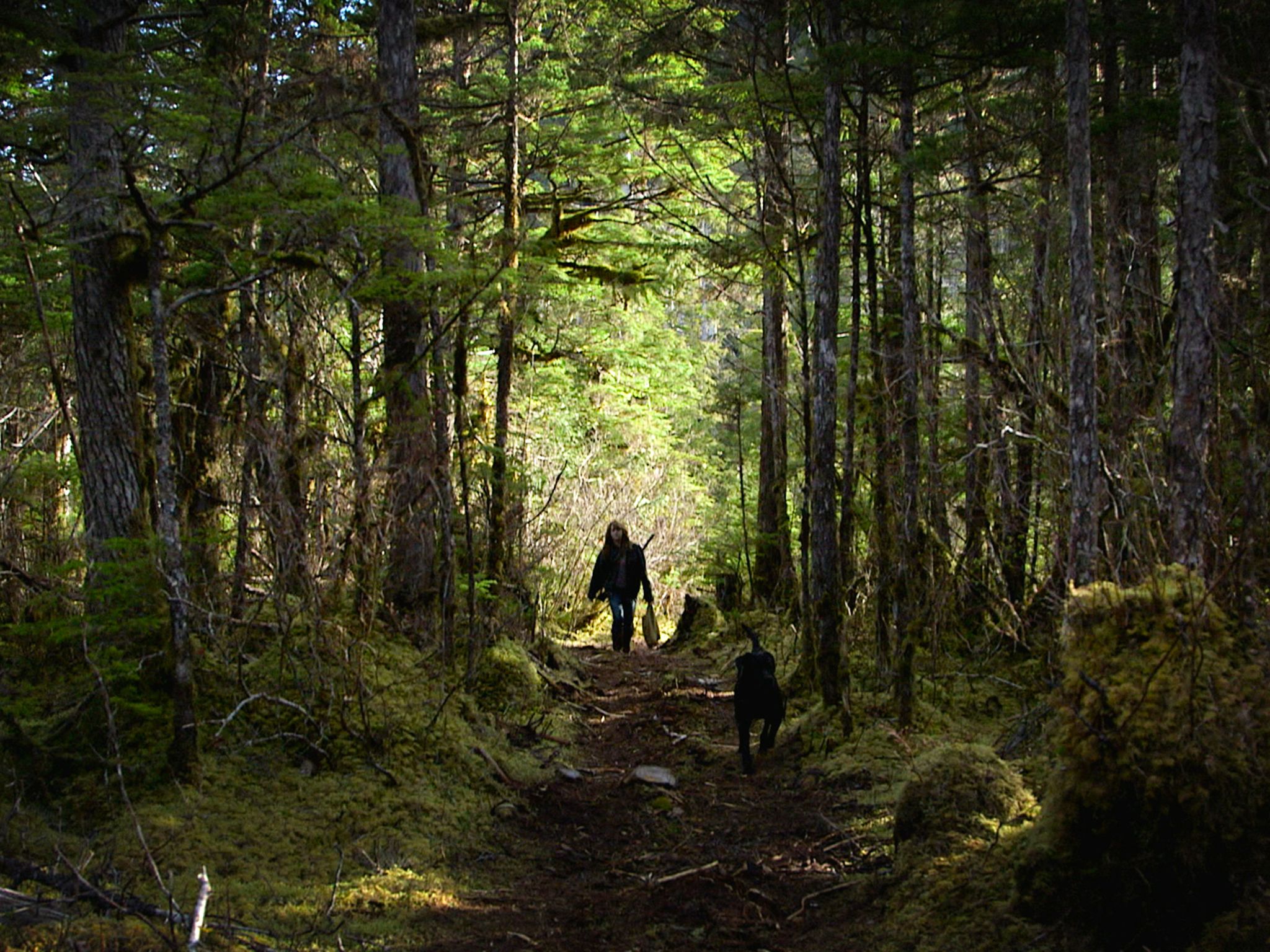 Port Protection, Alaska: Timbi walks through the woods with her dog, Smokey. This image is from... [Photo of the day - November 2015]